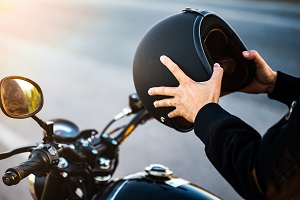 man putting on motorcycle helmet